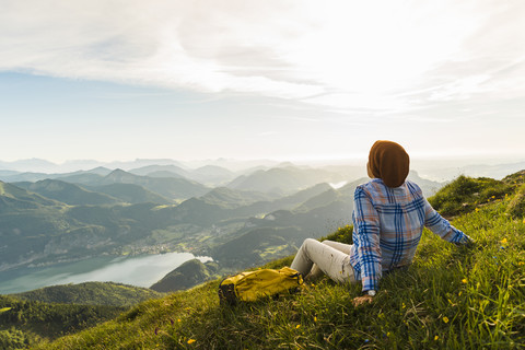 Wanderer, der eine Pause einlegt, mit Blick auf die Alpen, lizenzfreies Stockfoto