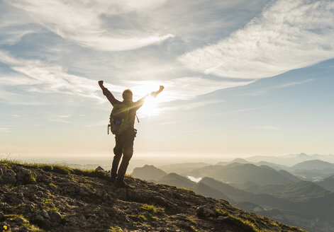 Austria, Salzkammergut, Hiker reaching summit, raising arms, cheering - UUF11000