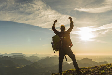 Austria, Salzkammergut, Hiker reaching summit, raising arms, cheering - UUF11002