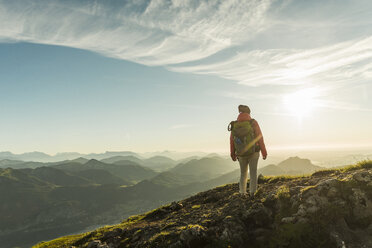 Austria, Salzkammergut, Hiker standing on summit, looking at view - UUF11009