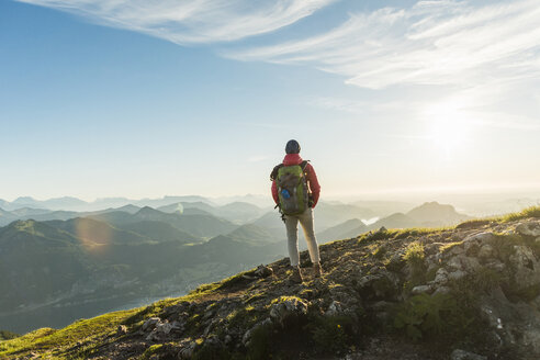 Wanderer steht auf einem Berggipfel und betrachtet die Aussicht - UUF11015