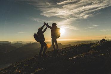 Austria, Salzkammergut, Cheering couple reaching mountain summit - UUF11023