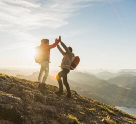 Austria, Salzkammergut, Cheering couple reaching mountain summit - UUF11024