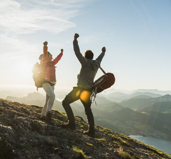 Austria, Salzkammergut, Cheering couple reaching mountain summit - UUF11025