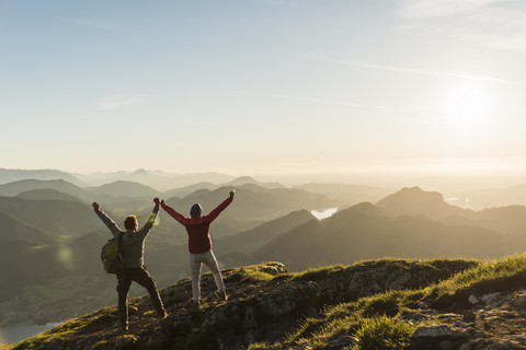 Österreich, Salzkammergut, Jubelndes Paar erreicht Berggipfel, lizenzfreies Stockfoto