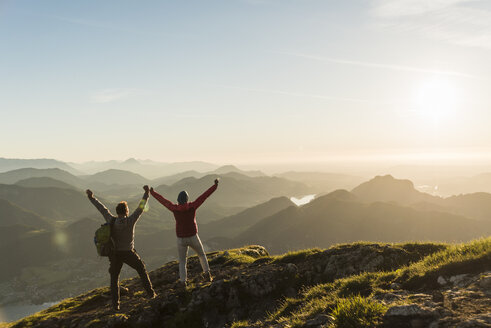 Austria, Salzkammergut, Cheering couple reaching mountain summit - UUF11026