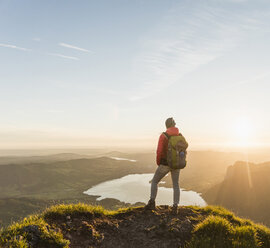 Hiker standing on mountain summit, looking at view - UUF11040