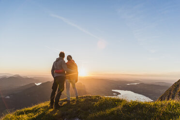 Austria, Salzkammergut, Couple standing on mountain summit, enjoying the view - UUF11045