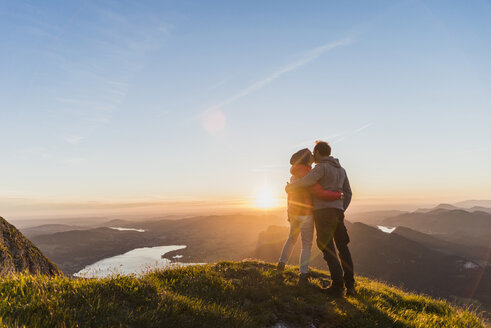 Austria, Salzkammergut, Couple standing on mountain summit, enjoying the view - UUF11046