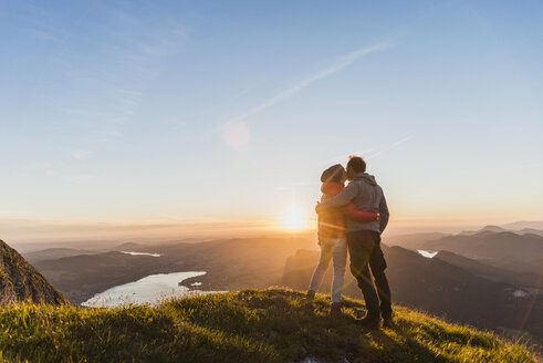 Österreich, Salzkammergut, Pärchen steht auf Berggipfel und genießt die Aussicht - UUF11046