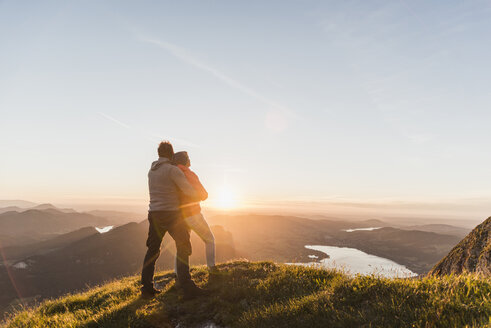 Österreich, Salzkammergut, Pärchen steht auf Berggipfel und genießt die Aussicht - UUF11047