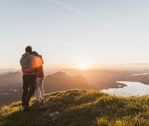 Österreich, Salzkammergut, Pärchen steht auf Berggipfel und genießt die Aussicht - UUF11049