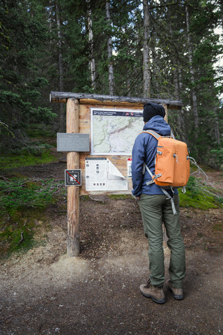 USA, Wyoming, Yellowstone National Park, Mann vor einer Informationstafel stehend, lizenzfreies Stockfoto
