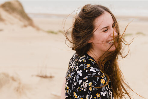 Porträt einer lachenden Frau mit wehendem Haar am Strand - NMSF00124