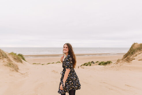 Portrait of smiling you young woman on the beach - NMSF00125