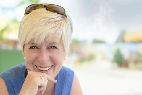 Porträt einer lächelnden älteren Frau an einer Strandbar, lizenzfreies Stockfoto
