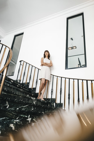 Erfolgreiche Geschäftsfrau auf einer Treppe stehend, lizenzfreies Stockfoto