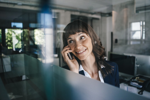 Frau im Büro beim Telefonieren, lizenzfreies Stockfoto