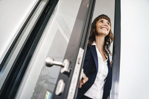 Businesswoman opening glass door - KNSF02013