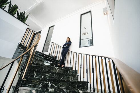 Erfolgreiche Geschäftsfrau auf einer Treppe stehend - KNSF02015