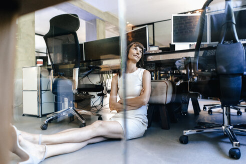 Geschäftsfrau sitzt auf dem Boden und träumt - KNSF02073