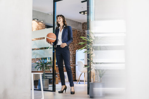 Geschäftsfrau hält Basketball im Büro - KNSF02097