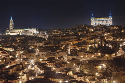 Spain, Toledo, view to lighted cityscape with cathedral and Alcazar in the background at night - DHCF00089