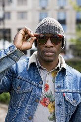 Portrait of stylish man wearing wooly hat and sunglasses - MAUF01161