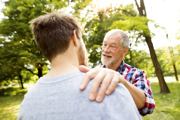 Happy senior father and his adult son in a park - HAPF01863