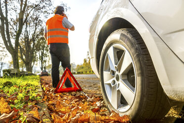 Back view of man on cell phone having a car breakdown - PUF00651