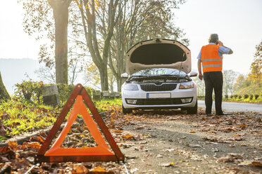 Back view of man on cell phone having a car breakdown - PUF00655