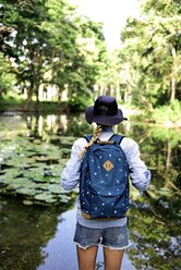Back view of woman with backpack looking at lake - ECPF00002
