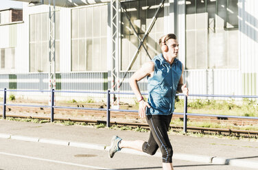 Junge Athletin beim Joggen in der Stadt - UUF11107