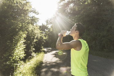 Jogger im Park trinkt Wasser - UUF11114