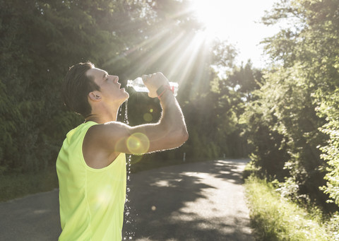 Jogger im Park trinkt Wasser, lizenzfreies Stockfoto