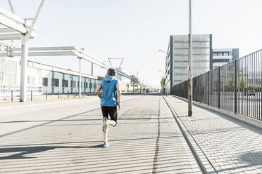 Junge Athletin beim Joggen in der Stadt - UUF11120