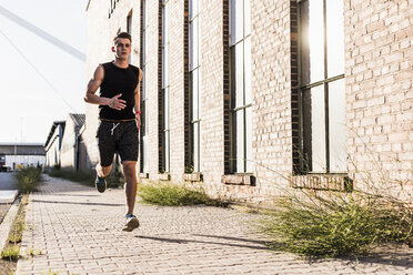 Junge Athletin beim Joggen in der Stadt - UUF11121