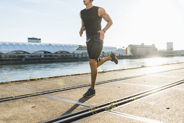 Junger Sportler beim Joggen in der Stadt am Fluss - UUF11124