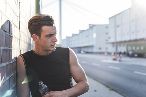 Deutschland, Mannheim, Junge Sportlerin in der Stadt mit Wasserflasche, Porträt, lizenzfreies Stockfoto