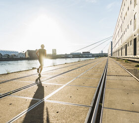 Junger Sportler beim Joggen in der Stadt am Fluss - UUF11138