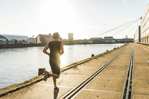 Young athlete jogging in the city at the river - UUF11140