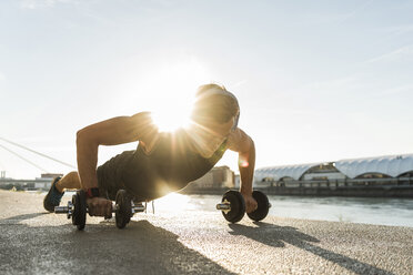 Fit athlete doing push ups at the river - UUF11145