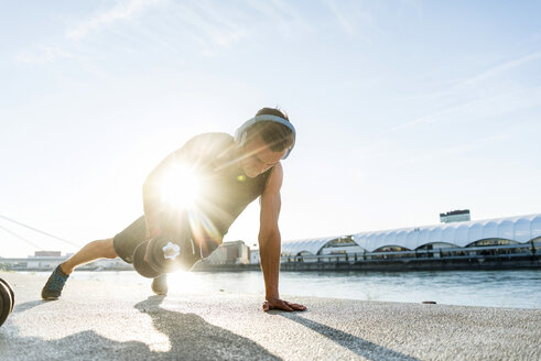 Fit athlete doing push ups at the river - UUF11147