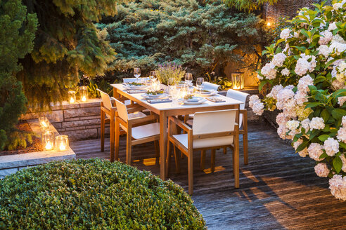 Gedeckter Tisch auf beleuchteter Terrasse - WDF04055