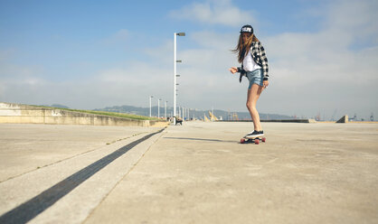 Junge Frau beim Longboarden auf der Strandpromenade - DAPF00769