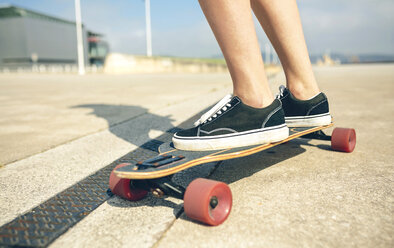 Feet of young woman on longboard, close-up - DAPF00770