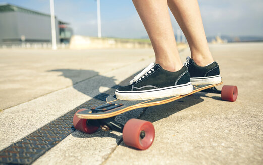 Füße einer jungen Frau auf einem Longboard, Nahaufnahme - DAPF00770