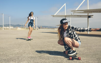 Zwei junge Frauen beim Longboarden auf der Strandpromenade - DAPF00775