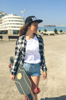 Junge Frau mit Longboard auf der Strandpromenade - DAPF00783