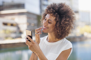 Young woman preparing for selfie, checking make up - ZEF14119